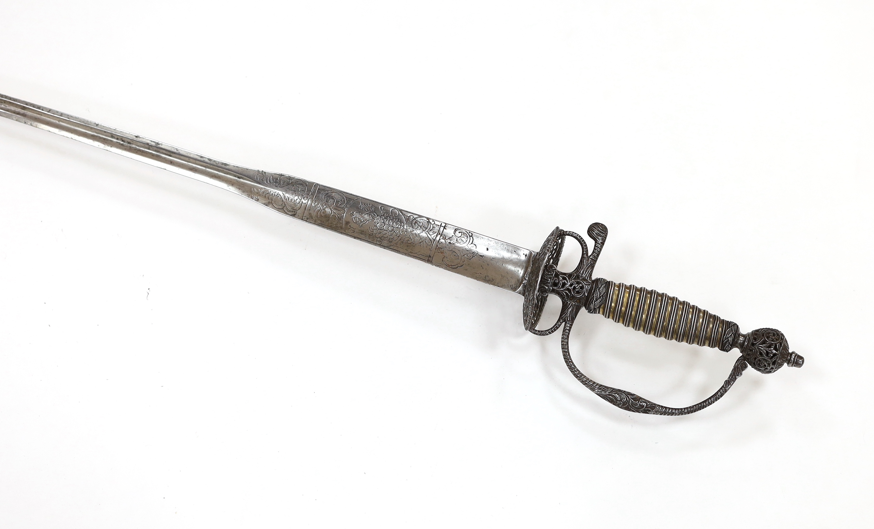 An English iron hilted small sword, c.1765, chiselled and pierced with scrolling devices and foliage, silver gilt tape and silver wire bound grip, colichemarde blade etched with scrolls and squirrel, blade 81.5cm